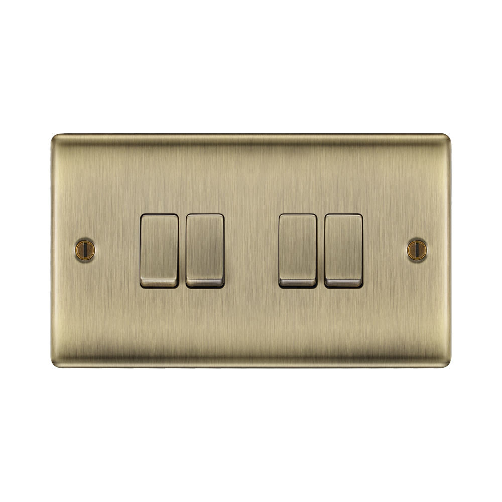 Brass light switch panel with four rectangular switches on a white background