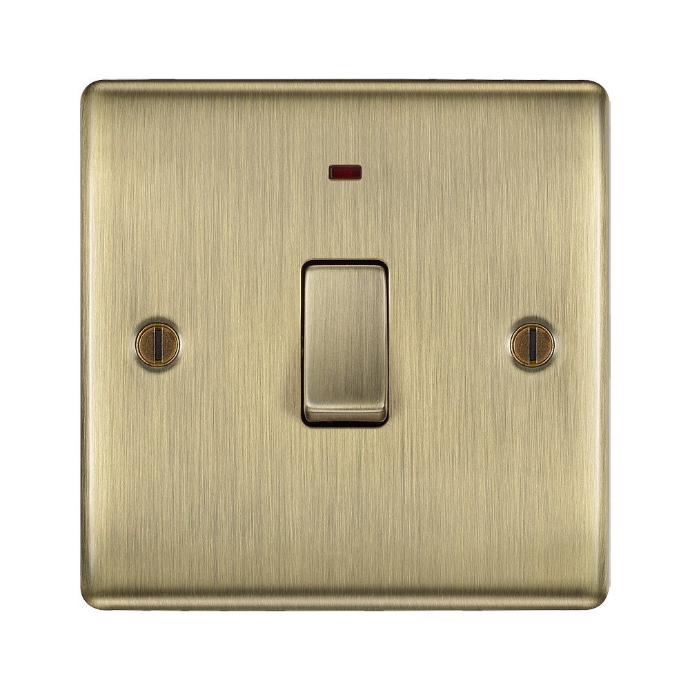 Brass light switch with a red indicator on a white background