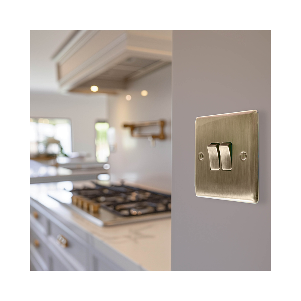 Brass light switch on a kitchen wall with a blurred background