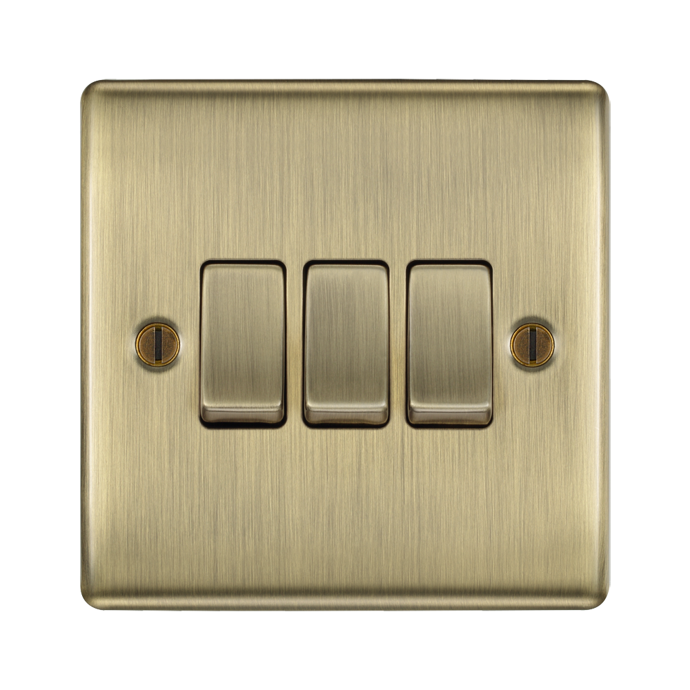 Brass light switch with three switches on a white background