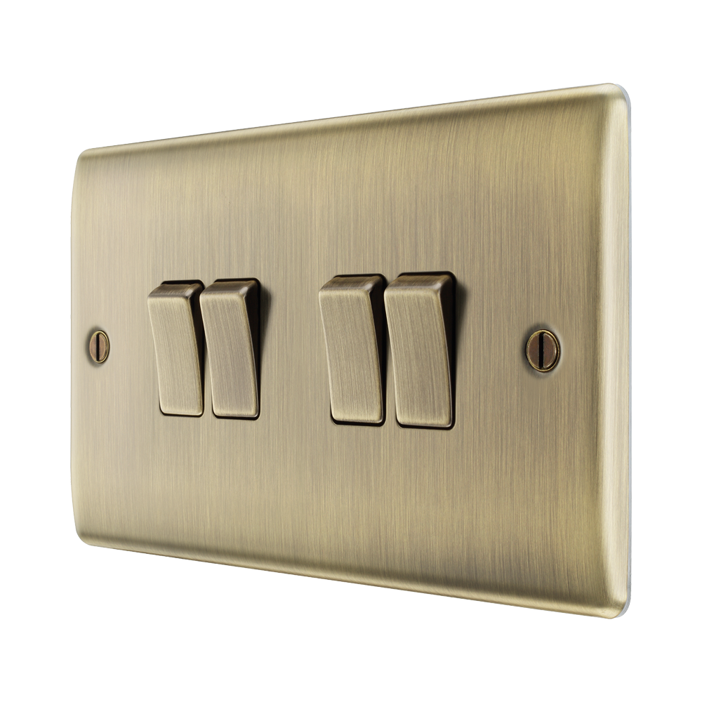 Brass light switch panel with four switches on a white background